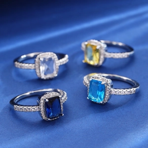 Elegant vintage square zircon rings in multiple colors on luxurious blue silk background