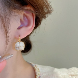 Detailed view of French vintage gold square hoop earring with star and zircon detail