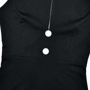 Detail shot of black halter dress featuring white decorative buttons and fine stitching