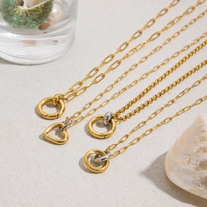 Vue macro de colliers en acier inoxydable or 18 carats avec pendentifs ronds et cœurs