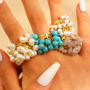 Detail of bohemian beaded ring featuring white pearls, blue turquoise, and purple natural stones