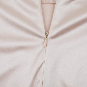 Détail de la fermeture éclair invisible sur robe de soirée en satin champagne soyeux