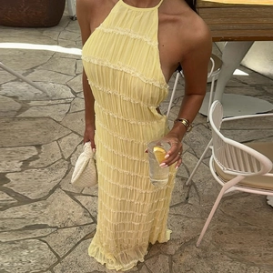 Detail of bright yellow halter neck dress showing textured pleats and open back design