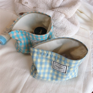 Detail of plaid canvas makeup bag with metal zipper and Time to Party label