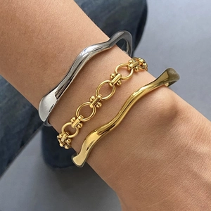 Three-piece layered jewelry set with gold and silver wave open bangles and chain bracelet