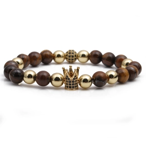 Macro detail of crown bead with black zircons on brown tiger eye stone bracelet
