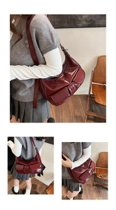 Detail of burgundy glossy PU leather bag featuring dual front pockets and silver zippers