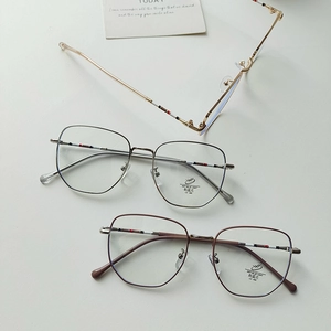 Detail of retro light eyeglass frames featuring iconic red, white, and blue stripe temple tips