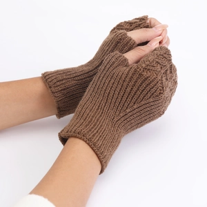Detailed knit texture of brown fingerless winter gloves worn by a person on white background