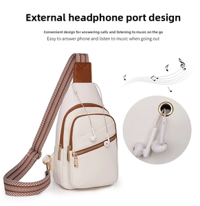 White chest bag detail showing the built-in headphone port and layered zipper pockets