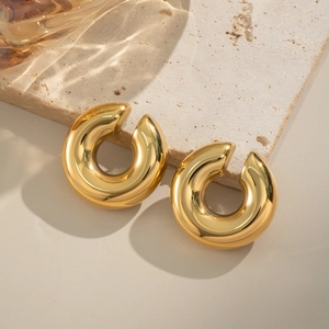 Minimalist 18K gold plated C-shaped chunky hoop clip earrings on a textured stone surface