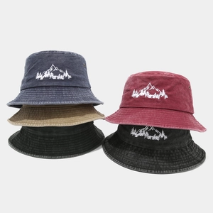Cappelli a secchiello in cotone lavato con ricamo bosco di montagna in vari colori.