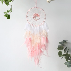 Pink Tree of Life dream catcher wall hanging with feathers and crystals on white wall