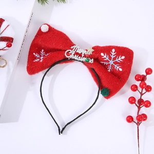 Detailed view of red plush Christmas bow headband with silver Merry Christmas embroidery