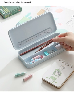 Detail of light blue stationery box with internal dividers and a 15cm ruler