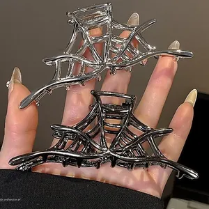 Detail of punk style metallic spider web hair claw clip in silver and gun black finish