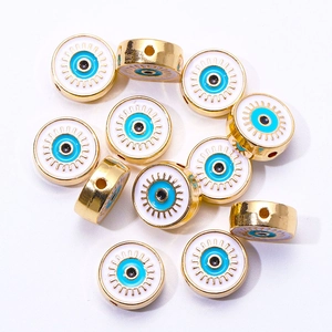 Macro shot of gold Turkish evil eye beads for DIY jewelry making on white background