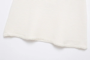 Détail de la jupe en tricot ivoire avec élégante bordure perlée et texture fine