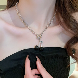 Close-up of black cherry pendant necklace with silver OT clasp on woman neck