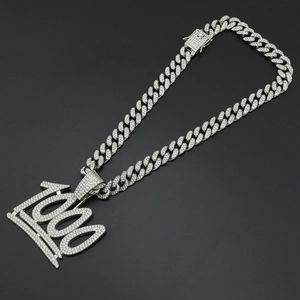 Vue macro du pendentif 1000 argenté avec couronne sur une chaîne cubaine glacée