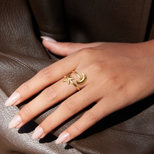 Polished 18K gold plated moon and star adjustable open ring on leather background