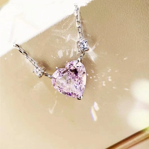 Macro shot of a pink heart-shaped crystal pendant with elegant side diamonds