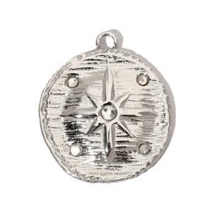 Macro detail of silver stainless steel starburst pendant with crystal inlay on hammered texture
