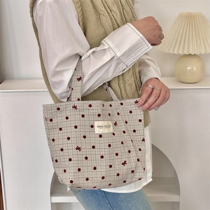 Détail du sac à lunch en toile avec pois rouges et broderie délicate de nœuds