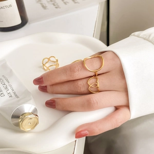 Elegant gold hollow heart geometric open rings for women on a minimalist ceramic tray