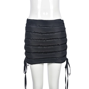Close-up of black quilted mini skirt with side drawstring ties and down-like texture