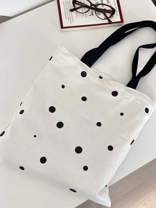 Minimalist white canvas tote bag with black polka dots and durable black handles