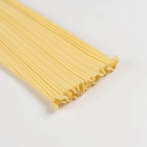 Détail du tricot côtelé jaune avec bords ondulés et texture de tissu doux
