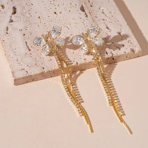 Detailed view of golden butterfly earrings with sparkling zircon fringe on stone