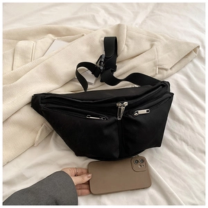 Detail of black nylon crossbody bag with dual zipper pockets and adjustable strap