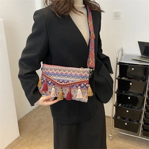 Close-up of bohemian crossbody bag with colorful tassels and embroidered strap