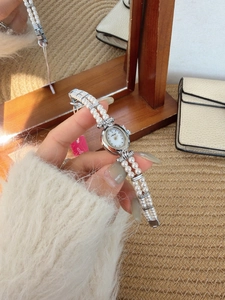 Macro view of a vintage oval pearl watch with white mother of pearl dial and silver case