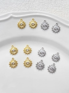 Close-up of 14k gold and silver evil eye sunburst charms for DIY jewelry making
