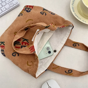 Close-up of brown corduroy tote bag showing interior pocket and metal snap fastener