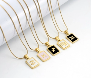 Detail of five 18K gold-plated zodiac necklaces on sleek snake chains with enamel charms