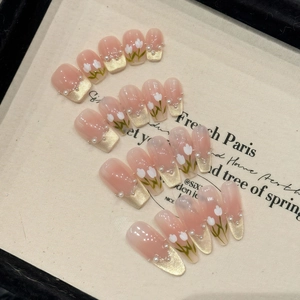 Faux ongles dégradés rose nude avec motif tulipe et détails de perles