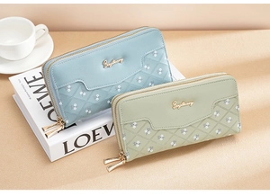 Detail of floral long wallets with dual zippers and quilted stitching on synthetic leather