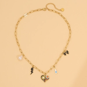Detail view of a gold chain necklace with heart, daisy, pearl, and bow charm pendants