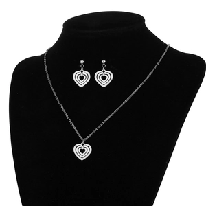 Polished silver stainless steel jewelry set featuring layered heart pendants on a model