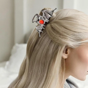 Gothic silver bat hair claw clip with red gemstone decoration on blonde hair