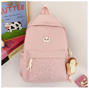 Detailed view of pink school backpack with cat graphic and plush bread charm accessory