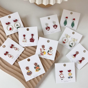 Detailed view of various Christmas enamel stud earrings featuring Santa and reindeer motifs