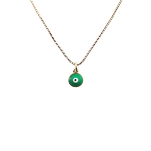 Dettaglio della collana dorata con piccolo ciondolo malocchio verde su sfondo bianco