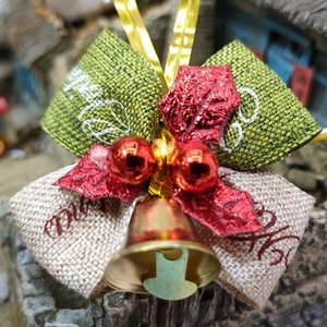 Detail of Christmas bell with green bow and red berries for holiday decoration