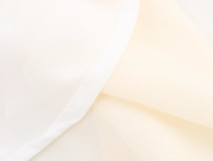 Macro shot of French ruffle dress fabric showing fine texture and quality stitching