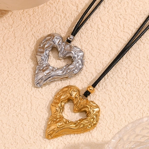 18K gold and silver hammered heart pendants on black cords with lava texture